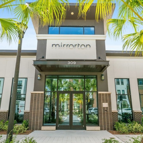 Mirrorton entrance to property with near lush landscaping